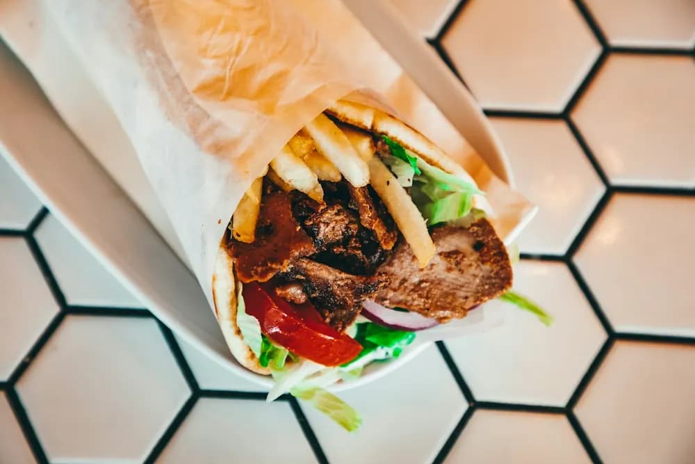 Kebab complet — pain kebab garni tenu en main
