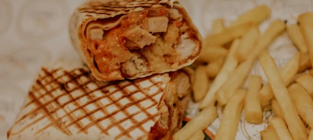 Tacos grillé coupé en deux avec des frites
